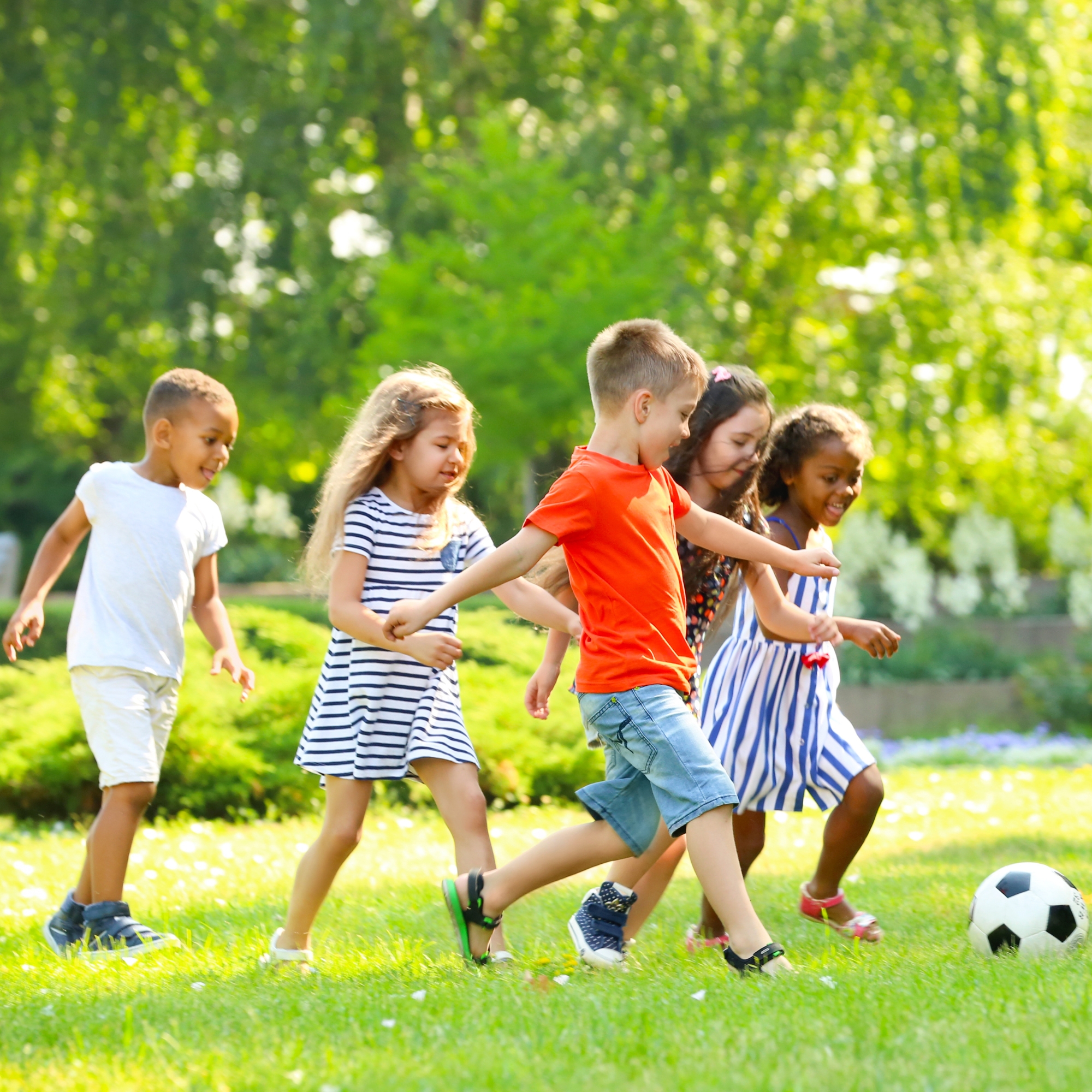 Enfants jouant ensemble dans l'herbe sous le soleil d'été